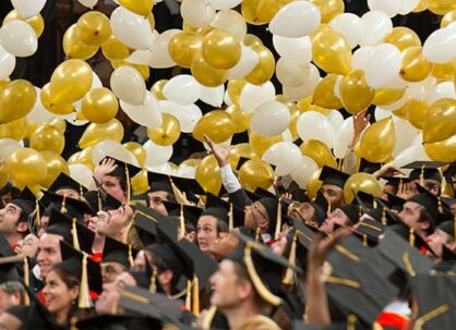 A graduation ceremony at Georgia tech with graduates and white and gold balloons