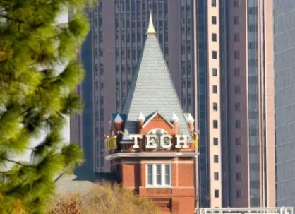Historic Georgia Tech building with modern skyscrapers in background.